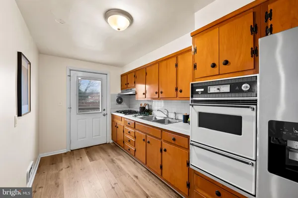 a kitchen with granite countertop cabinets stainless steel appliances and wooden floor