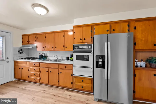 a kitchen with stainless steel appliances a refrigerator and a stove top oven