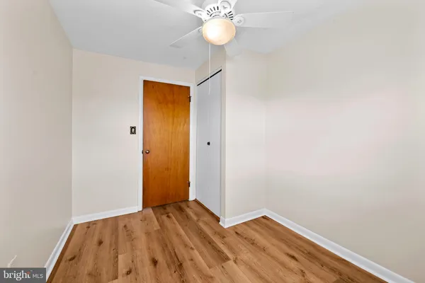 a view of a room with wooden floor and fan