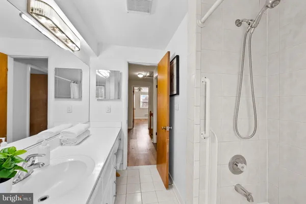 a bathroom with a tub sink vanity and shower