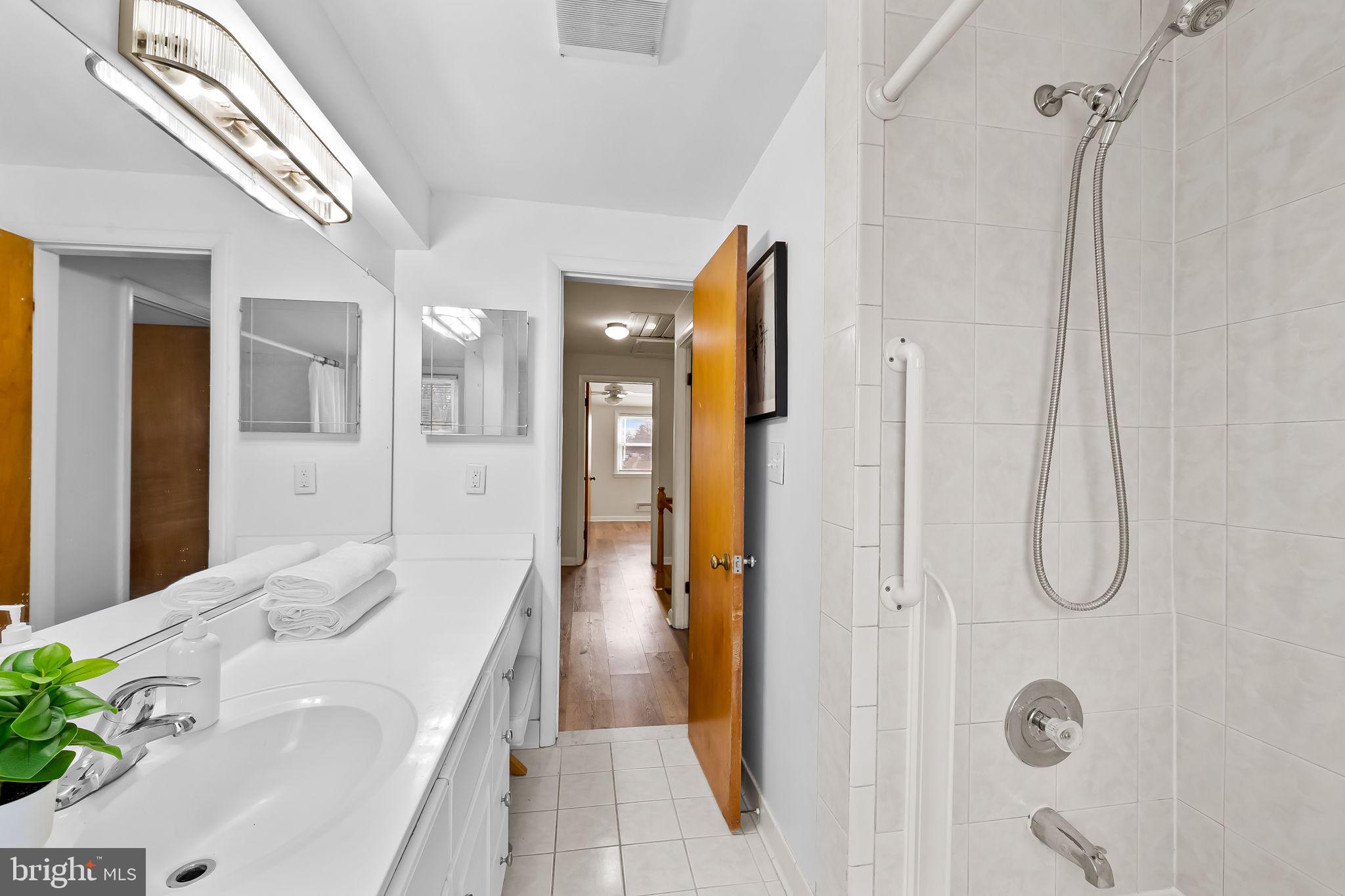 1011 Linden Avenue Baltimore, MD 21227 - Photo 28 of 40 a bathroom with a tub sink vanity and shower