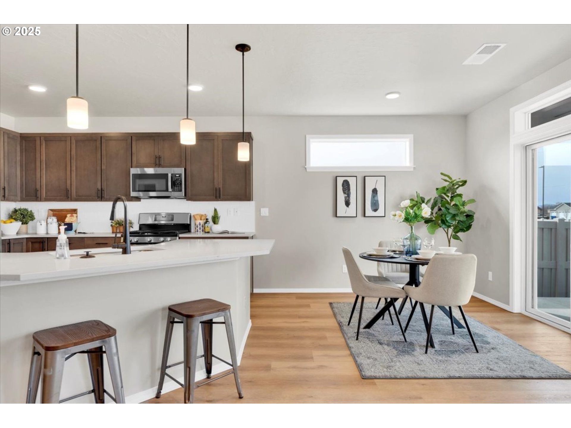 5190 Holly Street Springfield, OR 97478 - Photo 5 of 11 a kitchen with stainless steel appliances kitchen island granite countertop a table chairs and a refrigerator