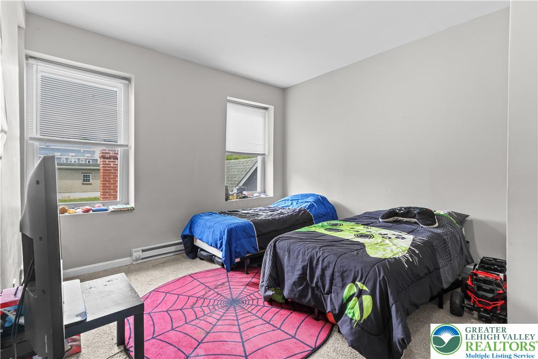 12 South Front Street Coplay, PA 18037 - Photo 27 of 41 This cozy bedroom features ample natural light and plush carpeting, creating a comfortable living space.
