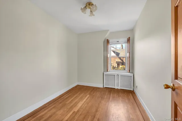 an empty room with a window and wooden floor
