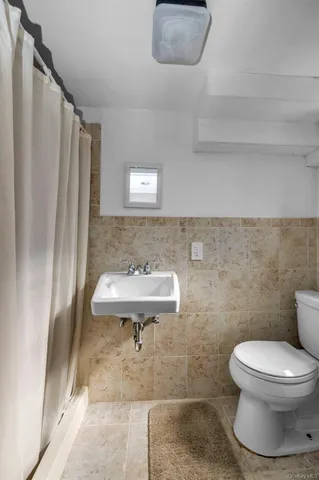 a bathroom with a sink a toilet and a mirror