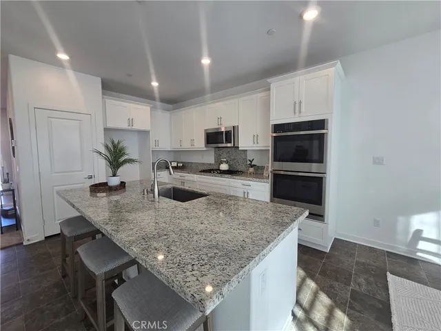 a living room with furniture a dining table and a potted plant