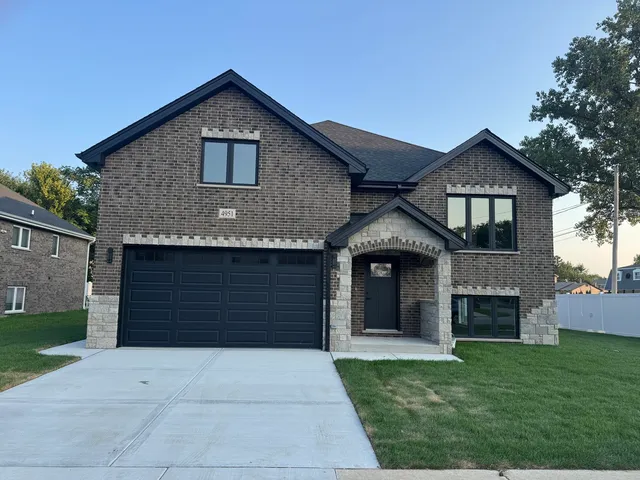 a front view of a house with a garden and garage