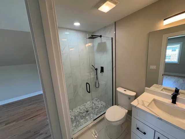 a bathroom with a granite countertop toilet sink and shower
