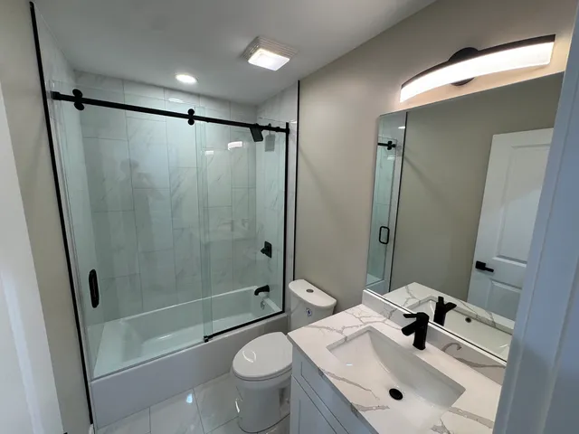 a bathroom with a sink mirror toilet and shower