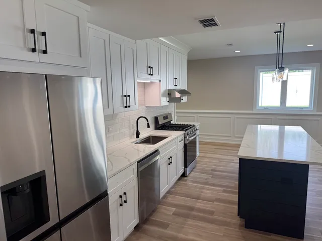 a kitchen with a sink a refrigerator and window