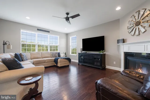 a kitchen with stainless steel appliances granite countertop a stove a refrigerator a kitchen island a sink dishwasher and white cabinets with wooden floor