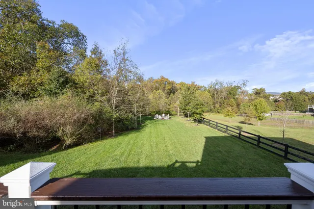 a view of a house with a big yard plants and large trees