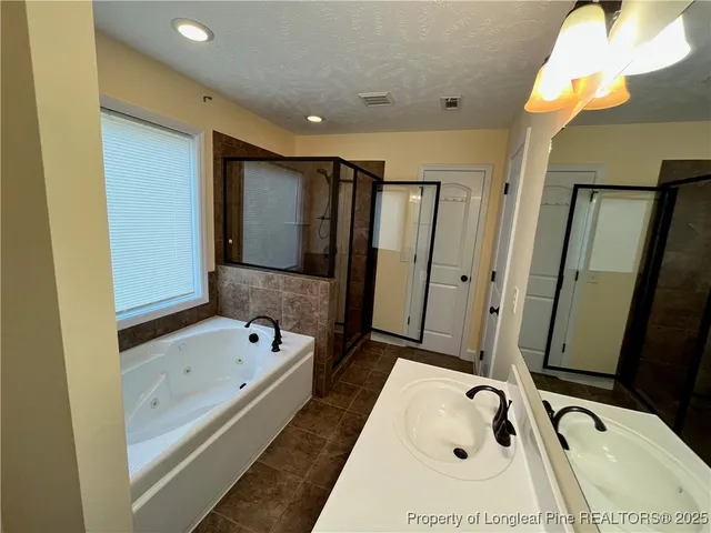a bathroom with a tub sink and mirror