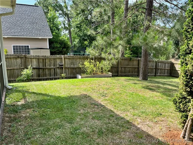 a view of a backyard with a garden and large trees