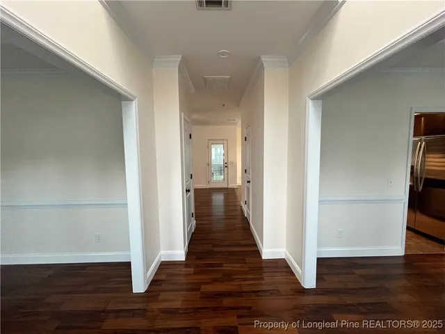 a view of a hallway with wooden floor and staircase