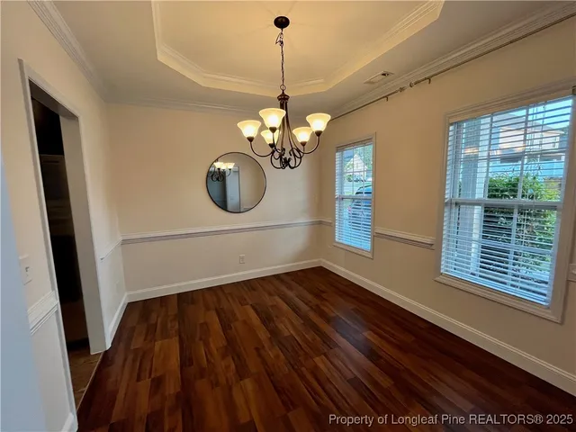 a view of a room with wooden floor and chandelier