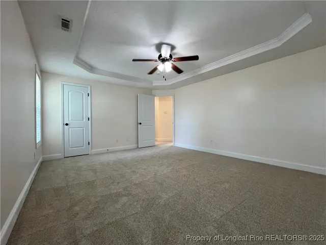 en empty room with ceiling fan and window