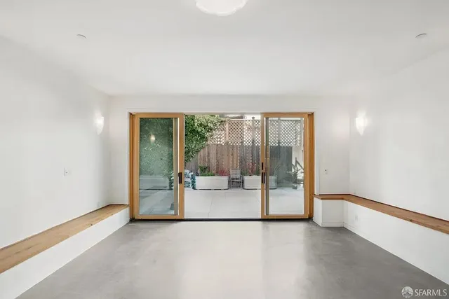 an empty room with floor to ceiling window and an outdoor view