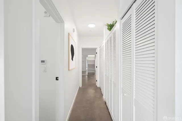 a view of a hallway with wooden floor and entryway