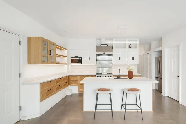a kitchen with stainless steel appliances kitchen island granite countertop a sink and cabinets