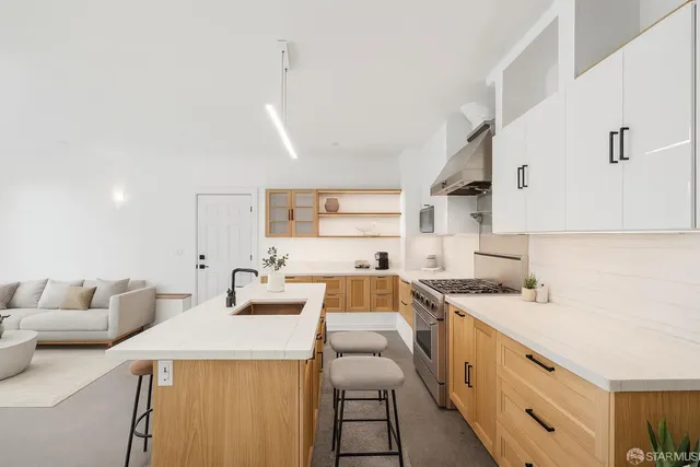 a kitchen that has a sink and a stove with white walls