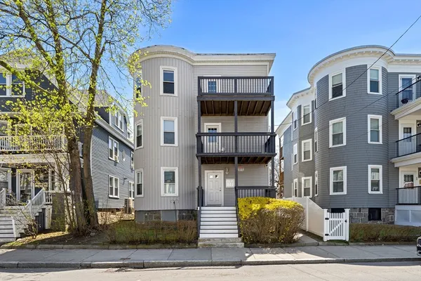 a front view of a residential apartment building with a yard