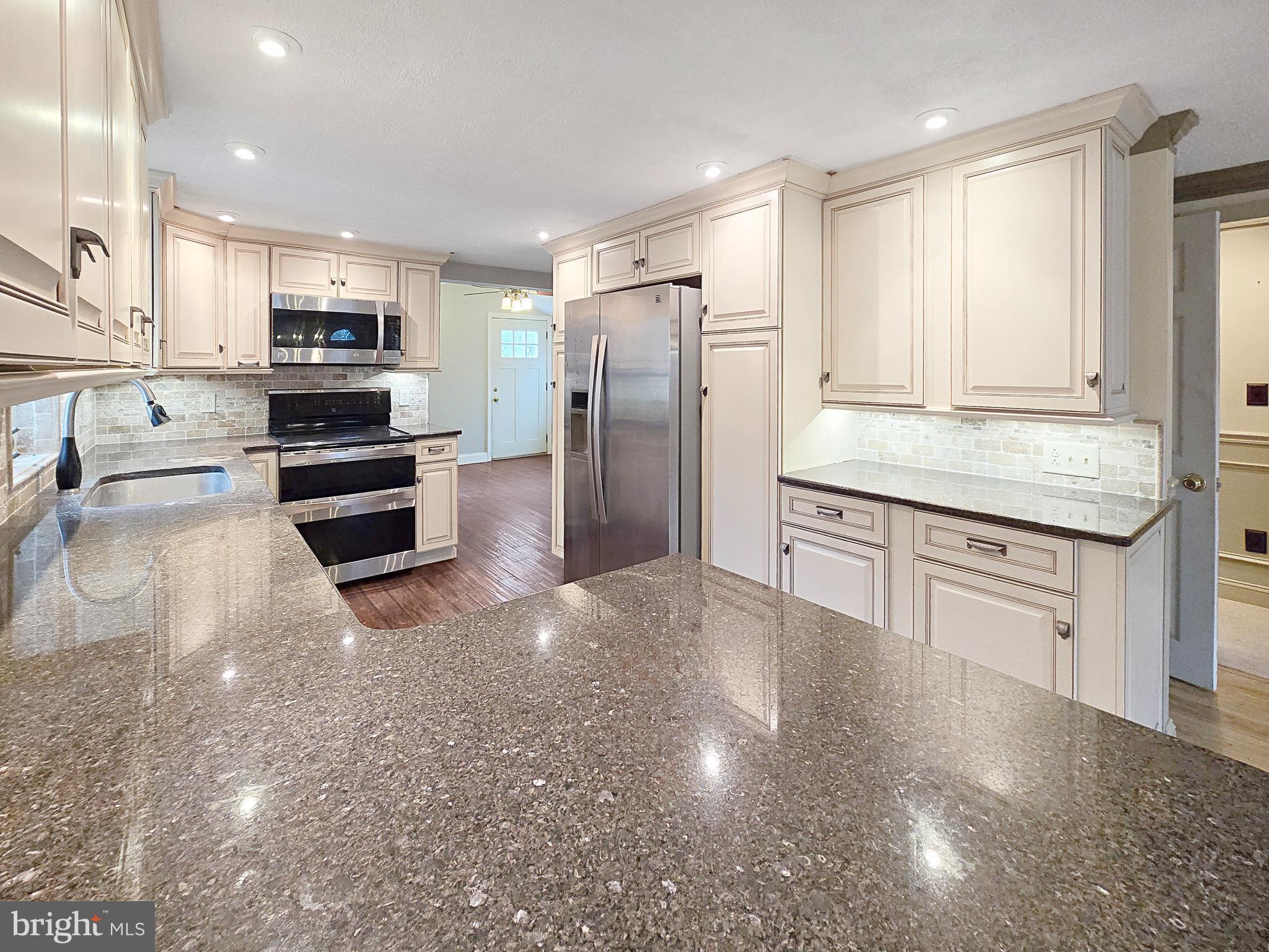 31 Diverty Road Pennington, NJ 08534 - Photo 8 of 29 a kitchen with stainless steel appliances granite countertop a refrigerator oven a sink dishwasher and white cabinets with wooden floor