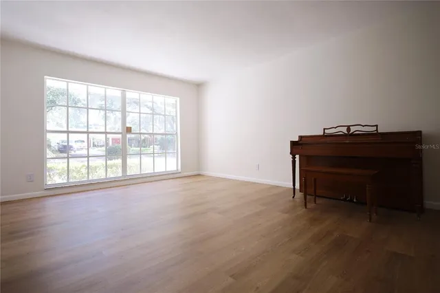 a room with a piano and windows