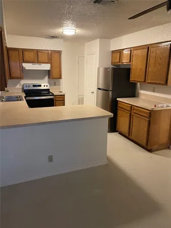 a kitchen with stainless steel appliances a refrigerator and a stove