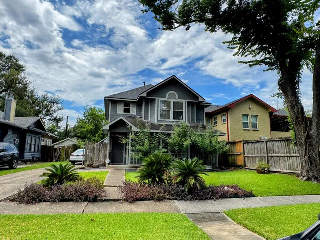 a front view of a house with a yard and potted plants