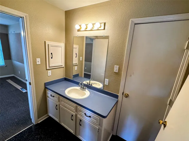a bathroom with a sink vanity granite and a mirror