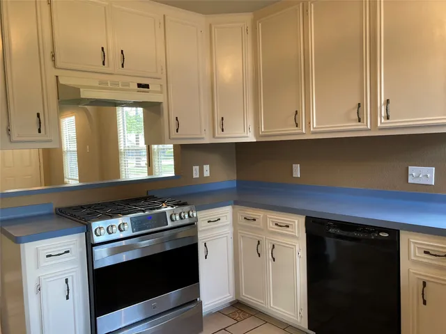 a kitchen with granite countertop white cabinets and white appliances