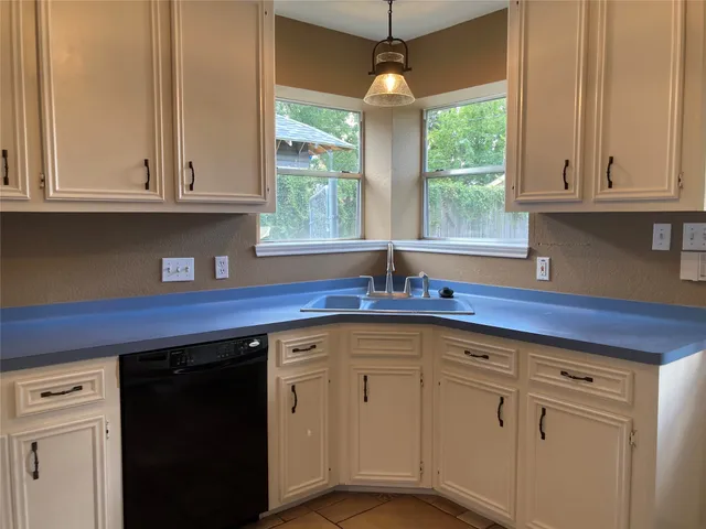 a kitchen with granite countertop white cabinets and a sink