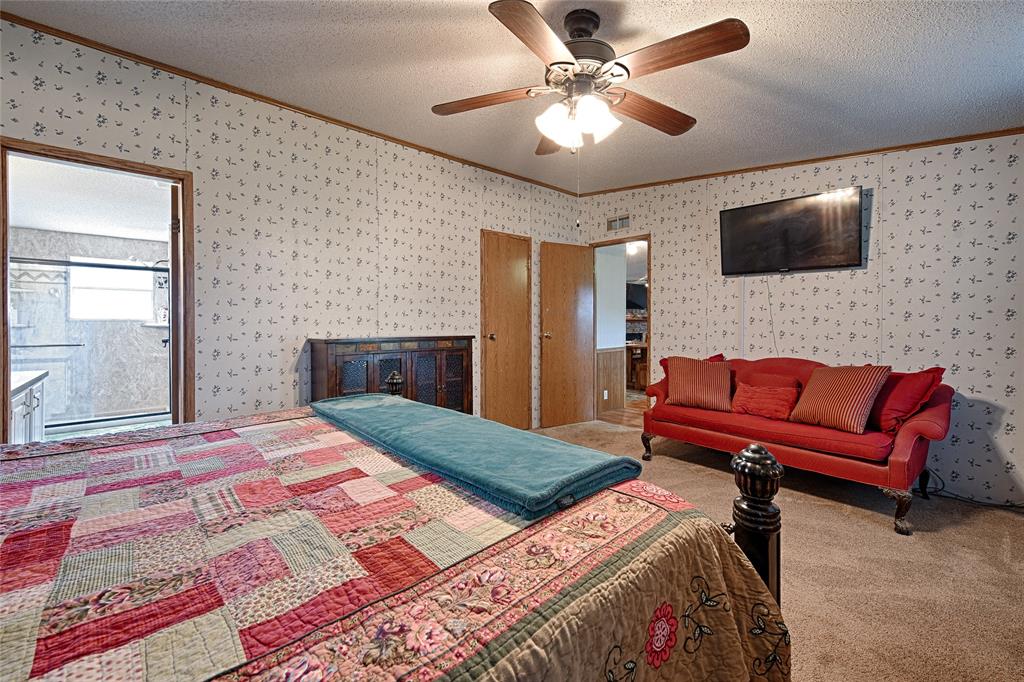 1670 Smith Circle Combine, TX 75159 - Photo 12 of 31 Carpeted bedroom with ornamental molding, a textured ceiling, wallpapered walls, and ceiling fan