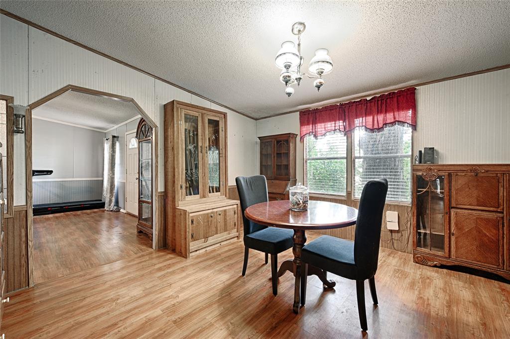 1670 Smith Circle Combine, TX 75159 - Photo 15 of 31 Dining space with wainscoting, arched walkways, wooden walls, crown molding, and light wood-type flooring