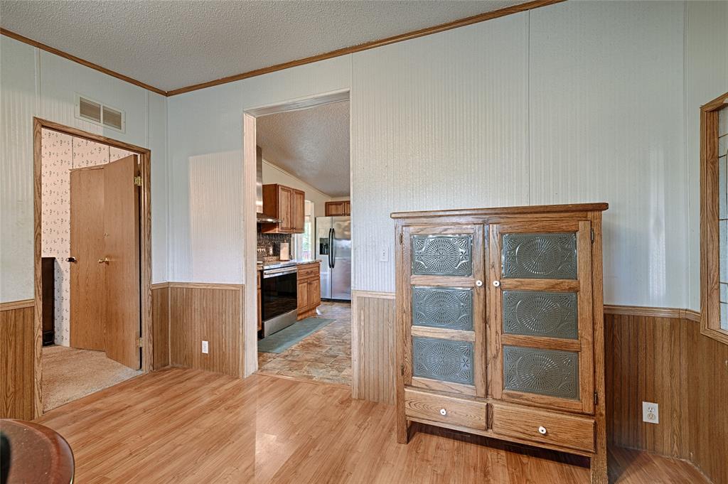 1670 Smith Circle Combine, TX 75159 - Photo 17 of 31 Corridor featuring wood walls, a wainscoted wall, and light wood-style flooring