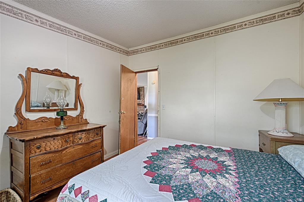 1670 Smith Circle Combine, TX 75159 - Photo 19 of 31 Bedroom featuring ornamental molding, a textured ceiling, and wood finished floors