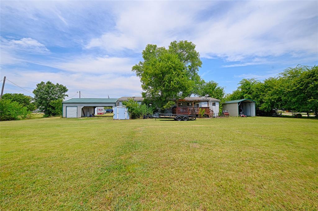 1670 Smith Circle Combine, TX 75159 - Photo 25 of 31 View of grassy yard with a storage unit and a carport