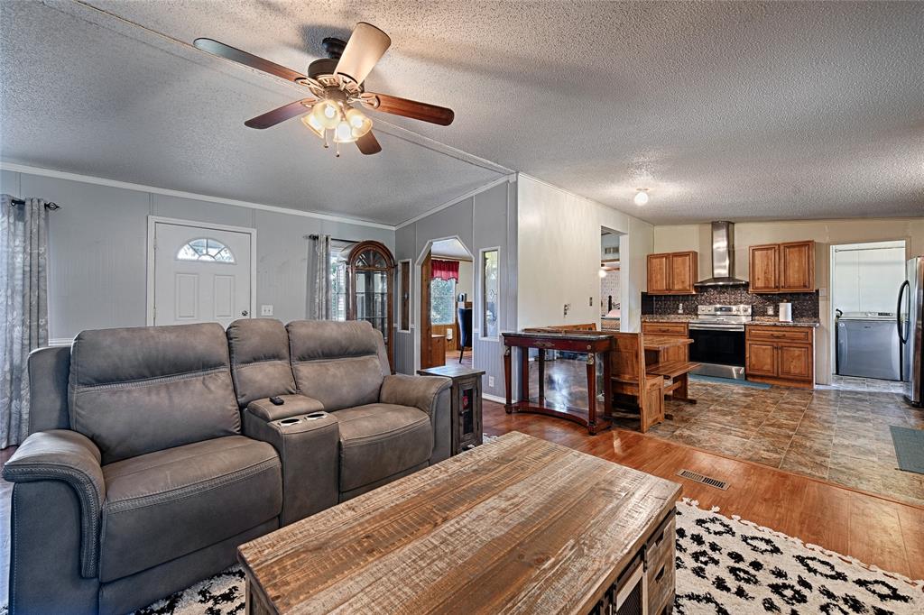 1670 Smith Circle Combine, TX 75159 - Photo 10 of 31 Living room featuring arched walkways, a textured ceiling, ornamental molding, wood finished floors, and ceiling fan