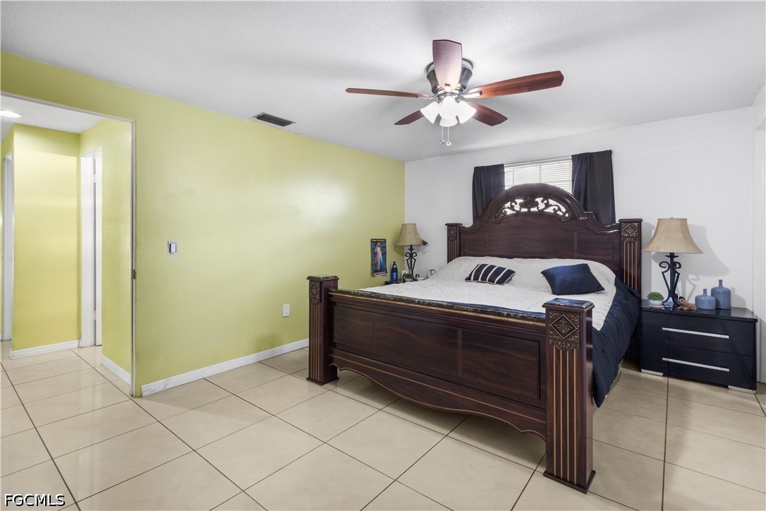18 Illinois Road Lehigh Acres, FL 33936 - Photo 20 of 45 a bed room with a bed and a ceiling fan