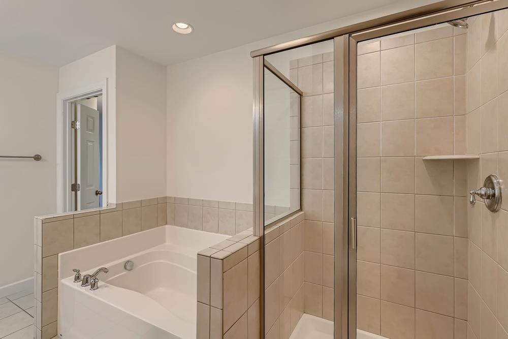 10907 Flower Bed Court Raleigh, NC 27614 - Photo 18 of 28 a bath tub sitting next to a white sink and vanity