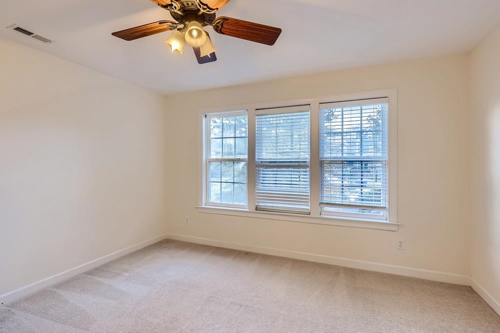 10907 Flower Bed Court Raleigh, NC 27614 - Photo 19 of 28 an empty room with chandelier fan and windows