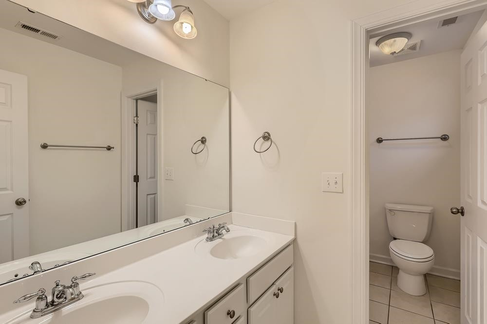 10907 Flower Bed Court Raleigh, NC 27614 - Photo 22 of 28 a bathroom with a granite countertop sink toilet a large mirror a vanity and shower