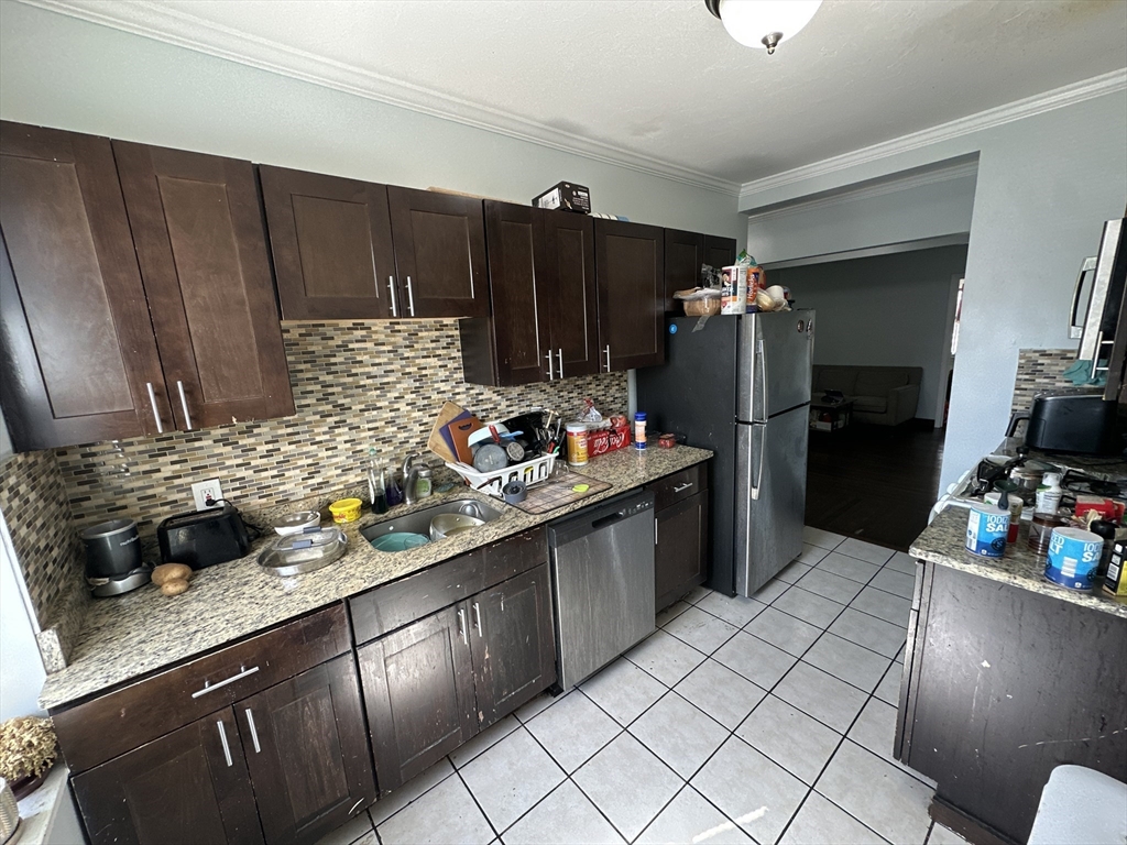 435 Walnut Avenue, Unit 10 Boston, MA 02119 - Photo 16 of 18 a kitchen with granite countertop a refrigerator and a sink