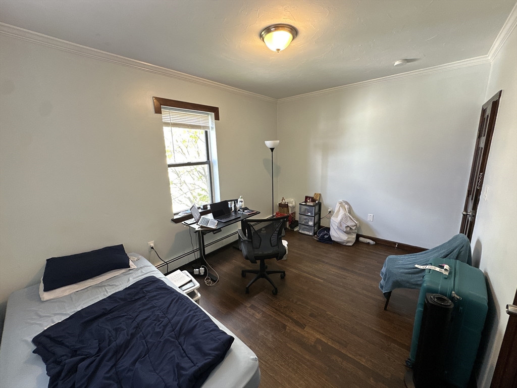 435 Walnut Avenue, Unit 10 Boston, MA 02119 - Photo 5 of 18 a bedroom with furniture and a window