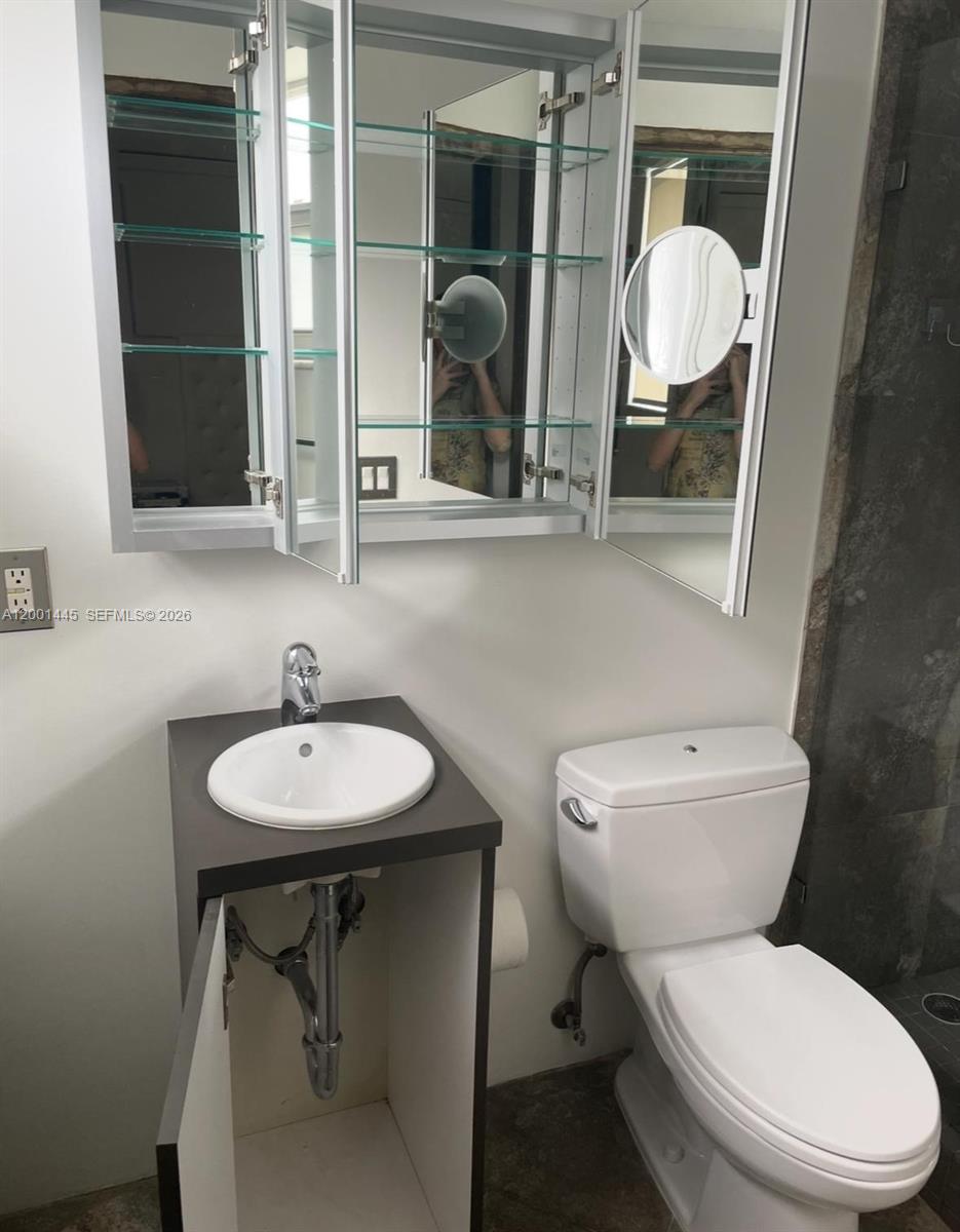 1300 Lincoln Road, Unit A301 Miami Beach, FL 33139 - Photo 19 of 23 a bathroom with a toilet a sink and mirror