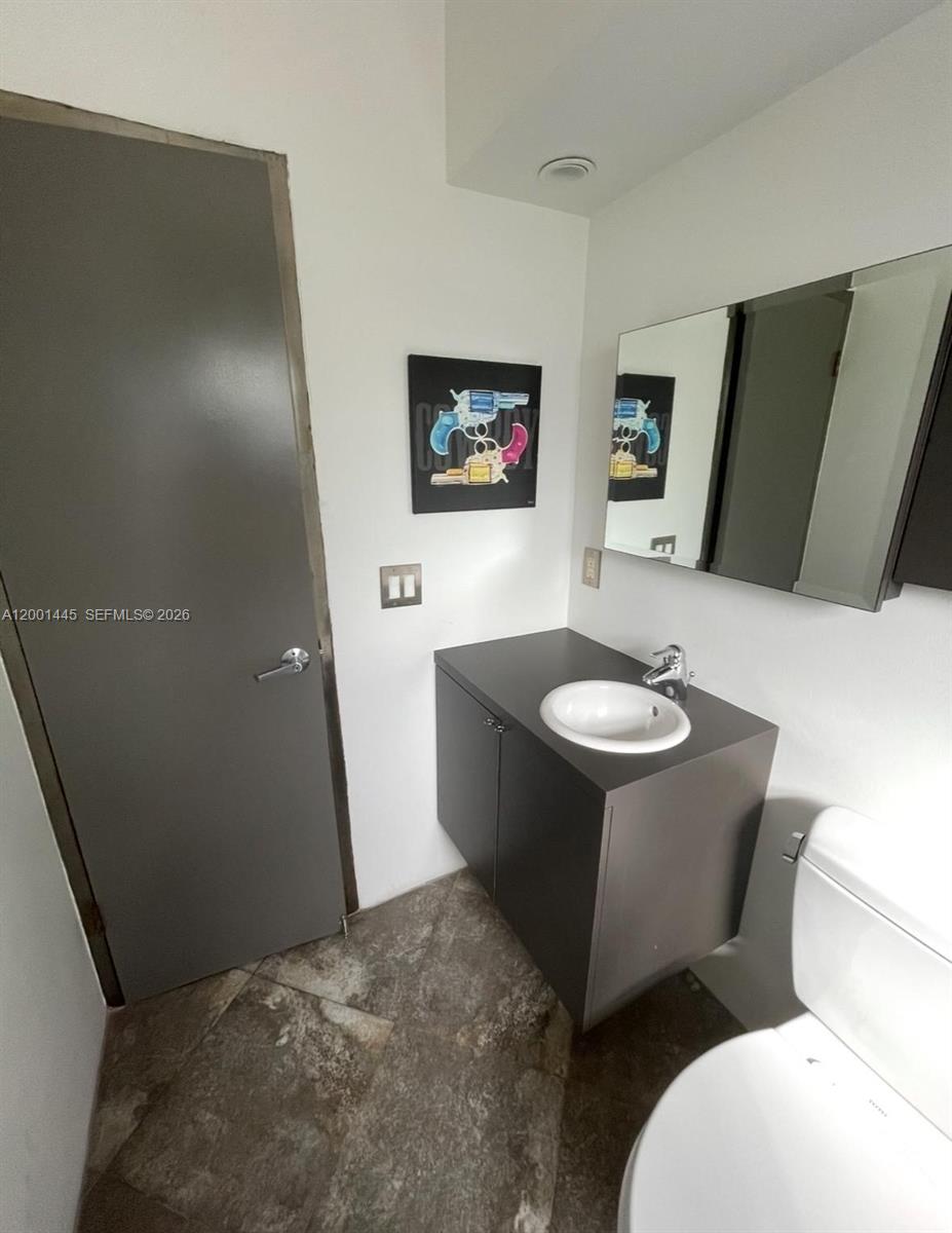 1300 Lincoln Road, Unit A301 Miami Beach, FL 33139 - Photo 7 of 23 a bathroom with a sink mirror and toilet