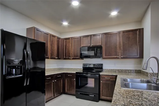 a kitchen with granite countertop a refrigerator and a sink