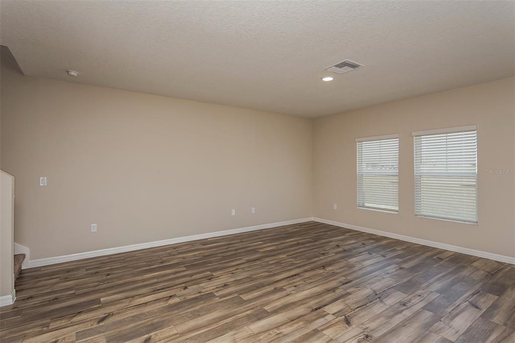 15232 Maude Lndg Loop Wimauma, FL 33598 - Photo 12 of 22 a view of an empty room with wooden floor and a window