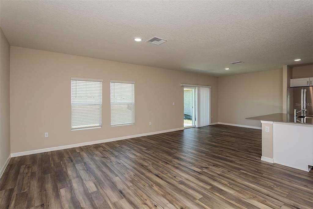 15232 Maude Lndg Loop Wimauma, FL 33598 - Photo 13 of 22 a view of empty room with wooden floor and fan